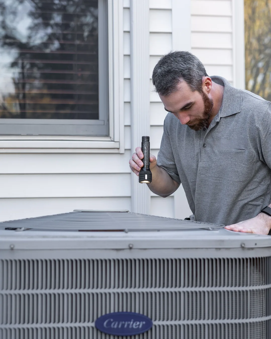 Technician servicing an outdoor HVAC unit